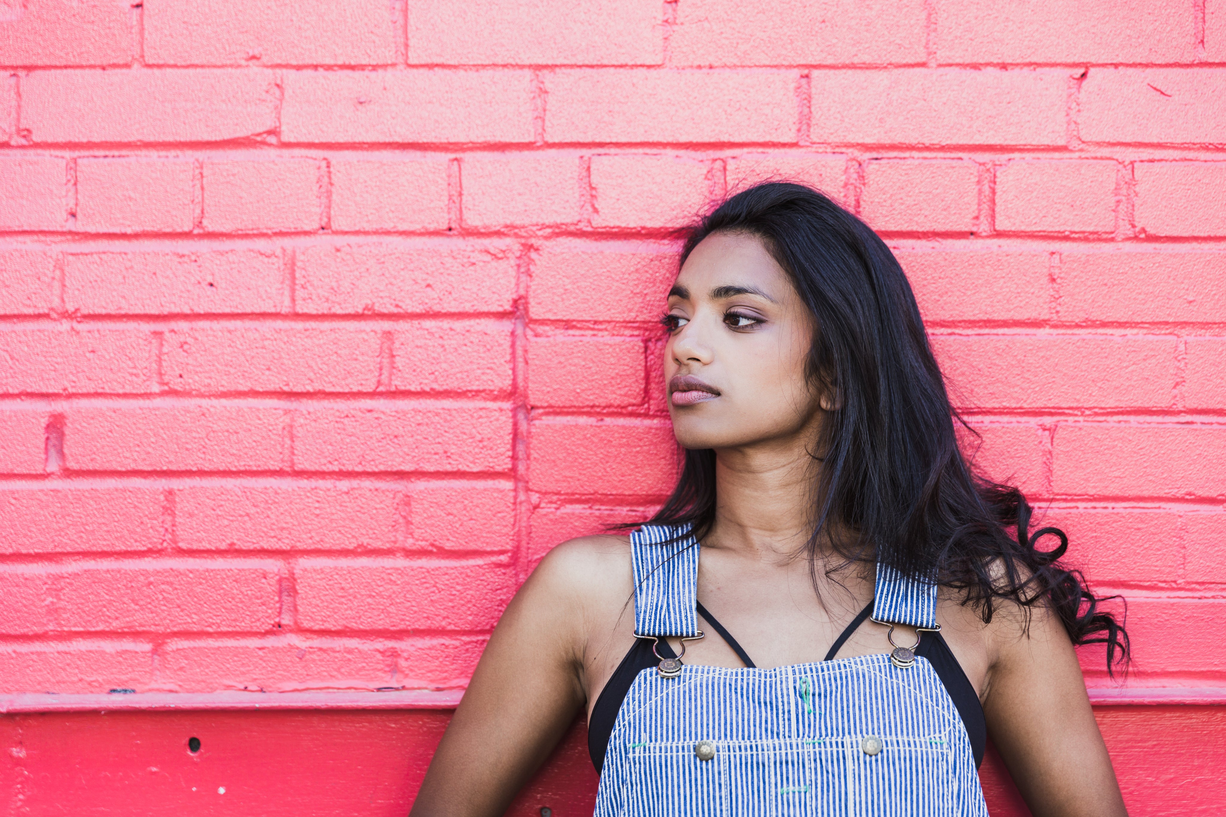 files/woman-close-up-leaning-against-pink-wall.jpg